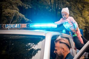 Zdjęcie przedstawiające policjanta oraz dziecko w radiowozie.