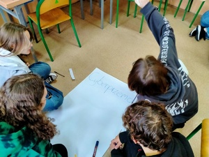 Zdjęcie przedstawiające dzieci w trakcie rysowania plakatu.